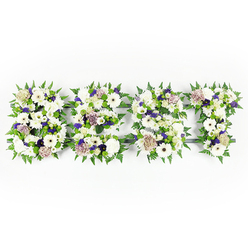 An intimate and thoughtfully arranged floral lettering spells DAD in a calm tapestry of whites, purples and greens, photographed flat against a bright white background so every curve of each letter is immediately legible. The composition balances velvety chrysanthemums and crisp ivory gerberas-their broad faces giving strength to the letters-with softly hued pastel coffee roses that lend a gentle, vintage warmth. Sprays of violet statice and small clusters of deeper purple filler flowers weave through the design, introducing a respectful touch of colour that reads as reverence rather than display. Each letter is outlined with lively fern fronds whose serrated edges create a rhythmic frame, while compact green button chrysanthemums sit within the letters to provide texture and freshness. A subtle dark structural base holds the shapes, visible only in shadowed seams, ensuring the lettering remains exact and dignified without detracting from the blooms.

As a local Stanmore arrangement, prepared at our workshop near Stanmore Broadway and often delivered to family services in the borough, this tribute carries a quiet scent of soft florals and green stems-comforting and understated. The mix of textures, from the plush petals to the crisp greenery, reads like an embrace: familiar, steady, and consoling. Whether placed beside a memorial photograph at a chapel near Canons Park or on a service table at a private home, this DAD tribute is designed to express gratitude, sorrow and enduring affection. Flower Delivery Stanmore assembles such personalised pieces with careful attention to proportion and sentiment, mindful of the comfort they bring to those who mourn.