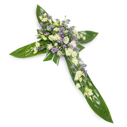 Viewed slightly from above on a stark white background, this floral cross combines structural greenery and tender blooms to create a composed expression of condolence. The cross backbone is an artful lattice of large, glossy green leaves-the kind of broad tropical foliage used to give weight and shape-each leaf catching a soft gleam of light along its veins. Centered at the crossroads of the arms, clusters of creamy ivory and pure white lisianthus bloom with layered, ruffled petals, their soft forms contrasted by clusters of compact white chrysanthemum or spray roses that create bright, textured highlights. Threaded through the main mass are many small lavender-purple sprays, likely limonium or tiny asters, which add a cool, serene punctuation against the warm ivories. Sparse, fine green fillers nestle among the flowers, lending a natural, meadow-like nuance that keeps the arrangement from feeling overly formal. The overall palette and texture-waxy leaf surfaces beside feathery petals-suggest a balance of permanence and fragility; the piece looks as though it might be carried gently into a chapel or laid at a graveside. The arrangement has a quiet, green scent and an understated dignity: ideal for families near Stanmore tube station or those arranging tributes for local wakes and services. Its restrained colours and cross silhouette communicate sympathy, faith and a wish for restful peace.