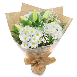 The image shows a carefully hand-tied bouquet of white and green flowers standing upright against a clean white background, every element arranged with thoughtful precision. At the centre, there is an abundance of daisy-like white chrysanthemums, their petals fine and luminous, encircling golden-green centres that add a hint of warmth to the otherwise cool palette. Emerging from this soft cushion of daisy blooms are sleek lily buds, still tightly closed, their elongated green forms tipped with creamy white. These buds lend height and structure to the design while suggesting the slow, unfolding beauty that will develop over the coming days in a home or chapel around Stanmore. Throughout the bouquet, delicate stems of gypsophila, commonly known as baby's breath, introduce a light, clouded texture, the tiny white blossoms scattering gently among the larger flowers. Deep, glossy green leaves frame the arrangement, their smooth surfaces reflecting the light, creating a rich backdrop that intensifies the brightness of the white petals. The stems are drawn together and wrapped in rustic brown kraft paper, folds overlapping in a conical shape that cradles the blooms with a simple, natural charm often favoured by local Stanmore florists. Over this sits a protective layer of clear, slightly crinkled cellophane that adds a polished finish and keeps the flowers secure for local delivery. The bouquet exudes a sense of quiet dignity and comfort, perfect for conveying sympathy, offering support at a time of loss, or bringing a gentle, uplifting presence into a room overlooking the green spaces and calm residential streets of Stanmore.