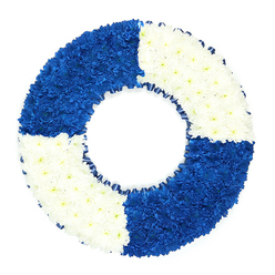 This image features a sophisticated nautical funeral wreath, styled as a lifebuoy and set against a clean, bright white background that makes every detail of the design stand out. The wreath is composed entirely of small, round blossoms, likely spray chrysanthemums, massed so closely together that their petals form a continuous, plush surface with no gaps. The ring is divided into four perfectly balanced sections that alternate between deep royal blue and crisp white, giving the piece a clear, graphic quality reminiscent of classic maritime safety rings. The blue quadrants, positioned at the top left and bottom right, carry a strong, dignified presence, while the white quadrants at the top right and bottom left soften the composition with light and purity. Along the inner rim, a slim dark blue ribbon is gathered into tiny ruffles, creating a gentle shadow line between the flowers and the central void, and exploring the theme of the sea with quiet restraint. The simple background ensures that the viewer's attention remains on the wreath's textures, its subtle curves, and the interplay of colour that lends it such emotional resonance. For families in Stanmore, this floral lifebuoy could serve as a heartfelt tribute at a funeral in local chapels or cemeteries such as those near Stanmore Hill, evoking memories of holidays on the coast or a life spent in maritime service. It communicates a sense of shelter and steadfast care, an unspoken promise that the one being remembered was, in their own way, a source of safety and hope for those around them.