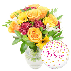 A cheerful, thoughtfully composed floral gift captured on a pure white backdrop, the bouquet resting in a clear glass vase that exposes neat, water-filled stems and the careful hand-trimming beneath. Large peachy-orange roses provide a warm, generous centre, their satiny petals curling outward with classic elegance, while bright yellow gerbera daisies scatter light across the arrangement with their flat, sunny faces and dark centres. Rich, burgundy carnations with tightly ruffled edges create a plush contrast and add visual weight, giving the composition a comforting, tactile quality. Small white alstroemeria blooms, faintly speckled, appear like delicate stars among the bolder flowers, lending a soft, sophisticated whisper to the palette. Varied green foliage-broad glossy leaves and slimmer sprigs-wraps the stems and lifts the arrangement, offering freshness and structure. A round white foil balloon sits to the bottom right, overlapping the vase slightly and decorated with playful gold and hot-pink confetti dots and tiny hearts; across its middle, the phrase "best Mum" is written in an elegant hot-pink script, a personal note that turns the bouquet into a heartfelt present. Picture this arriving on a quiet morning to a mum living near Canons Park or the quieter lanes off Roe Green; the mix of warm colours and gentle scent feels designed to brighten a kitchen table and bring an immediate smile.