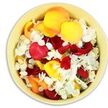 Viewed from directly above, a shallow, round bowl in a soft cream-yellow glaze is filled to overflowing with a carefully chosen blend of rose and hydrangea petals, the kind of gentle floral detail often requested from Flower Delivery Stanmore for meaningful goodbyes. The petals form a dense, cushion-like carpet, with no empty spaces or glimpses of the bowl's base, creating a feeling of abundance and care. Deep crimson and ruby red rose petals intermingle with bright sunshine yellow and soft peachy apricot petals, their velvety surfaces curling inward or folding over one another in natural, graceful shapes. Scattered liberally throughout are small, ruffled white petal clusters that recall hydrangea blooms, bringing a cool, airy lightness to the warmer tones. The light in the image is bright yet diffused, so the colours appear rich but not harsh, and subtle shadows between petals add depth and texture. This loose, organic arrangement suggests that the petals have been freshly gathered, perhaps early in the morning in Stanmore, and poured into the bowl just before a service. The emotional tone is quiet and reflective rather than festive, inviting thoughts of petals being gently taken from the bowl and scattered over a coffin or laid around a framed photograph in tribute. One can almost sense the softness under the fingertips and the delicate fragrance of rose rising from the mass of petals. The overall impression is of a simple, heartfelt offering: a bowl of nature's colour and scent, ready to honour a loved one with grace and tenderness.