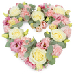 A tender, heart-shaped floral tribute fills the frame, set against a bright white background that allows every pastel tone and curve of the design to stand out clearly, much like the serene arrangements often chosen for funeral services across Stanmore. The heart is completely covered with flowers, giving it a lush, substantial appearance, as if it were a soft cushion of petals. Cream and pale yellow roses are positioned as gentle anchors, each bloom opening in perfectly formed spirals, the velvety petals catching soft highlights and subtle shadows. Between them, countless pastel pink carnations cluster together, their finely ruffled edges creating a rich, textured surface that softens the silhouette of the heart. Deeper magenta-pink lisianthus blooms are dotted throughout, their slightly trumpet-shaped flowers introducing a graceful contrast in both colour and form, adding depth without disturbing the calm palette. Woven among the blossoms, silvery-green eucalyptus leaves form a delicate framework, their rounded, muted foliage cooling the arrangement and outlining the heart's contours with quiet elegance. Tiny yellow-green buds peek from within, hinting at new growth and the freshness of recently cut stems. The combination of cream, blush pink, and soft green suggests serenity, compassion, and a dignified farewell. This heart-shaped wreath would suit many occasions of remembrance in Stanmore-from intimate family goodbyes to more formal ceremonies-offering a gentle, floral way to express sympathy, love, and cherished memories when words feel too small.