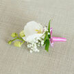On a natural linen backdrop the colour of pale oatmeal, a single orchid boutonniere is displayed with the poise of a miniature sculpture, the kind you might choose for a quiet, elegant wedding in Stanmore or a refined prom celebration nearby. At its centre, a pristine white Phalaenopsis orchid opens in full bloom, its petals thick, velvety, and calm, spreading outward like folded silk under soft daylight. In the heart of the flower, a gentle yellow-orange flush and a trace of pink create a delicate focal point, hinting at warmth and emotion without disturbing the boutonniere's overall serenity. Encircling the orchid is an airy constellation of baby's breath-tiny Gypsophila blossoms that float like clouds, giving the design a soft-focus, romantic texture. To one side, three pale green orchid buds nestle along a slender stem, still closed and plump with promise, adding depth and the symbolism of new chapters beginning. Fine, vivid green leaves are tucked lightly among the blossoms, their lines sleek and modern, grounding the whiteness with flashes of fresh colour. At the base, the stems are gathered and wrapped in a vivid pink satin ribbon, smooth and lustrous, finished with a neat, small bow whose ends rest just so against the fabric. The contrast between the cool white flowers and the playful ribbon feels both classic and contemporary, perfectly suited to a modern couple saying their vows in a Stanmore church or registry office. Crafted with the eye of an experienced florist, every petal and sprig appears placed with intention, creating a keepsake that speaks softly of joy, care, and attention to detail.