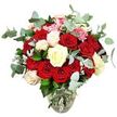This photograph showcases a lavish, rounded bouquet of roses arranged in a transparent glass vase, set against a pure white background that strips away distractions and allows the colours and textures to take full focus, reminiscent of a carefully styled arrangement in a Stanmore townhouse. The vase has a gently bulbous base with a narrower neck, holding the stems in a natural, flaring formation that supports a generous dome of flowers. At the heart of the design sit numerous deep red and vivid scarlet roses, tightly clustered, some in neat buds and others fully open with plush, velvety petals that evoke intense romance and affection. Interwoven among these are creamy white and ivory roses, along with a few white blooms tinged delicately with pale pink at the edges, bringing softness, light, and a touch of tenderness to the composition. Small, bright pink filler flowers appear here and there, like little bursts of colour tucked between the larger roses, adding texture and a playful, celebratory feel. Long stems of blue-green eucalyptus, with their rounded leaves and misty, silvery look, arc elegantly through the bouquet, suggesting a cool, fresh scent that might drift through a window overlooking Stanmore's leafy streets. Dark green rose foliage and touches of paler, silvery-green leaves help define the bouquet's rounded silhouette and create a lush, abundant impression. Through the clear glass of the vase, you can see the straight stems and the clear water that keeps them vibrant, implying recent, expert preparation by Flower Delivery Stanmore for same-day arrival in homes and venues around Canons Park and beyond. The arrangement feels both classic and modern, perfect for an anniversary surprise, a romantic dinner, or any special moment that calls for a heartfelt gesture captured in flowers.