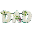 A classic DAD funeral tribute is captured in this image, its simplicity and elegance making it a fitting choice for a memorial service in Stanmore, whether in a quiet chapel or beside a graveside surrounded by trees. The three capital letters are engineered as sturdy, three-dimensional shapes and completely cloaked in tightly packed, pure white chrysanthemums or similar small button blooms. Their overlapping petals create a smooth, plush surface that appears almost like soft fabric from a distance, giving the tribute a gentle, comforting presence. Around the outside edge of each letter, an emerald green satin ribbon is neatly ruffled and pinned, following the contours precisely. This ribbon forms a vivid frame that defines the letters clearly and introduces a fresh, natural contrast, reminiscent of Stanmore's local parks and green spaces. Subtle hints of a dark supporting frame and horizontal bars can be glimpsed behind the arrangement, indicating that the piece is designed to stand upright during the funeral.
Delicate adornments of additional flowers and foliage add a more personal touch. On the upper left side of the first D, a small cluster of white freesia and rich green leaves softens the outline, the freesias' slender stems and open blossoms bringing variation in shape and height. Two slender green stems extend from this accent and sweep diagonally across to the central A, linking the design and guiding the eye along the word. At the point where these stems meet the A, an asymmetrical focal spray features two deep purple calla lilies, their smooth, trumpet-shaped blooms cupping inward, nestled among more white freesia and glossy foliage. This deeper purple accent introduces a sense of quiet dignity and depth to the predominantly white and green tribute. The last D is finished with a smaller matching grouping of white flowers and greenery on its top right curve, balancing the composition. Together, these elements create a serene, respectful DAD arrangement that expresses love, sorrow, and meaningful remembrance for a father cherished by family and friends in Stanmore.