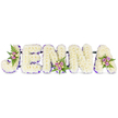 A profoundly tender memorial piece spells the name JENNA in bold, three-dimensional capitals set against a pristine white backdrop. Each letter is formed from tightly packed, creamy-white chrysanthemum blooms - or similarly small, soft-petalled flowers - producing a cloud-like, velvety surface you can almost feel by eye. A narrow border of deep purple ribbon or tiny lavender blooms traces the inner edges of every character, giving each letter a quiet definition and a gentle, consoling contrast to the white petals. Thoughtfully placed accent clusters soften the linear form: blush-pink and pale lavender spray roses, alongside a few cream or very pale yellow roses, sit tucked into the upper curve of the J, the lower centre of the first N, and the upper right of the A. Fine, dark-green fern fronds weave through these mini posies, adding cool foliage texture and a subtle forest-scented counterpoint to the sweeter rose perfume. The letters are subtly linked by slim, dark supporting bars at the base, indicating a sturdy, ceremony-ready framework that will stand on easels or a chapel dais. Soft, diffused light falls across the arrangement, catching the pearly sheen of petals and the satin of the purple edging, conjuring a mood of gentle remembrance rather than spectacle. As a bespoke funeral tribute, this composition reads as both deeply personal and respectfully restrained - a floral letterpiece suited to wakes, memorial services, or a quiet family farewell. Locally, this style is often requested by families around Stanmore Broadway and near the Tube, where neighbours choose simple, name-led tributes to honour a life with calm dignity.